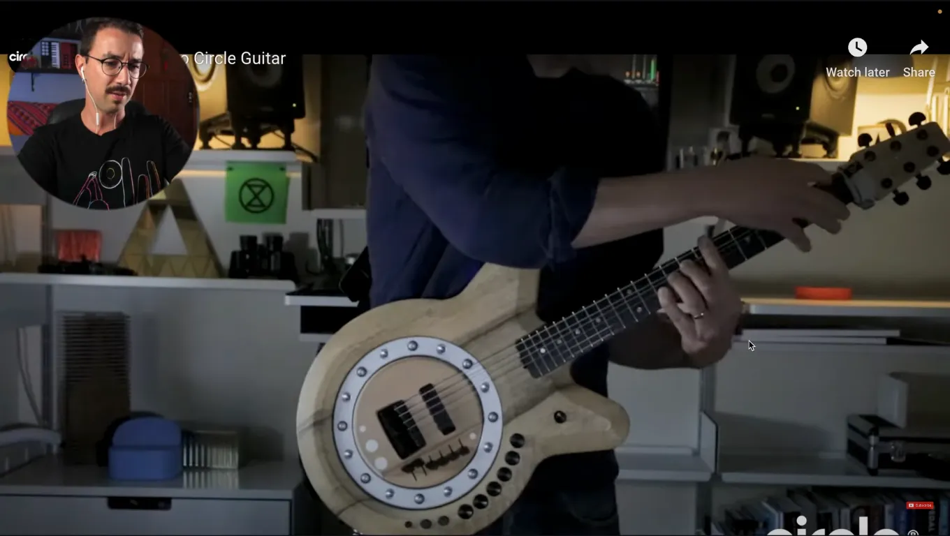 A performer plays the Circle Guitar, whose body surrounds a rotating string-striking wheel.